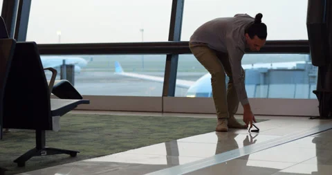 Man picking up wallet from floor, slow motion shot at airport terminal Stock Footage 306130644