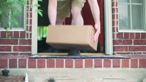 Man picks up a box delivery from his porch Stock Footage 132296086