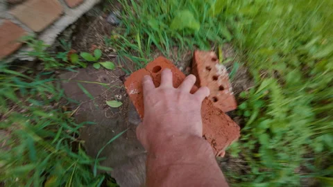 The man picks up bricks with his hand and throws them away. 스톡 동영상 342422313