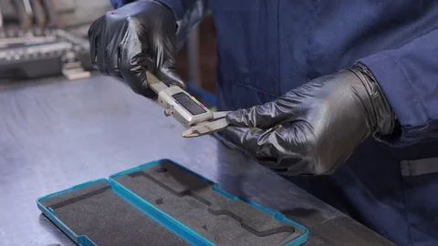 Man picks up an electronic caliper Stock Footage 102807102