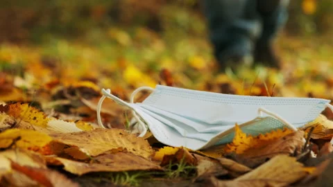 A man picks up a face mask in the fall. Stock Footage 146690014