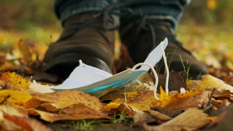 A man picks up a face mask in the fall. Stock Footage 146690370