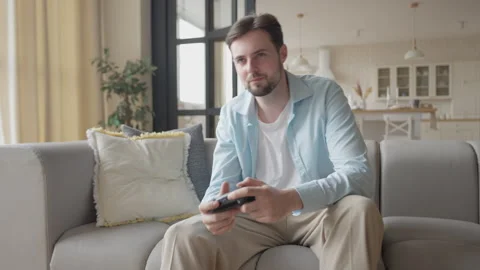 Man Picks Up Game Controller From Table And Starts Playing Video Game At Home 스톡 동영상 301247898