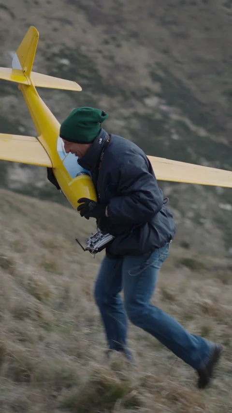 A man picks up his plane and climbs the hill Stock Footage 273607290