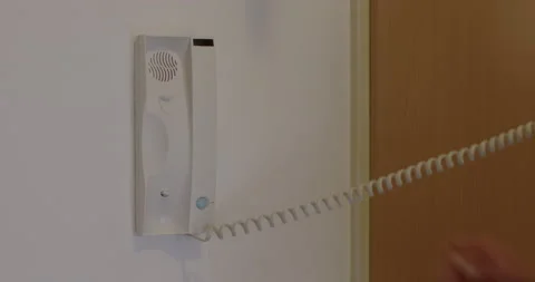 Man picks up intercom, opens the door by pressing button. Remote control Stock Footage 195345996