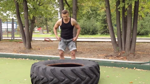 A man picks up a large tire on the Playground. Vidéo 66430783