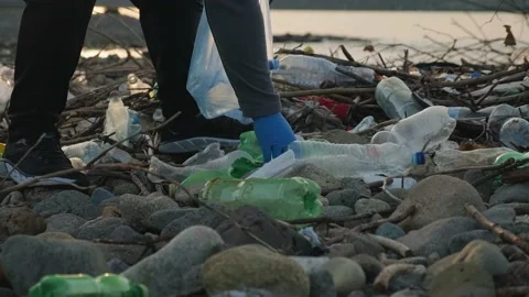 Man picks up plastic bottles in trash bag on the beach in Batumi city Stock Footage 226142663
