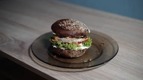 A man picks up a plate with a hamburger from the table and puts it in its place Stock Footage 128416729