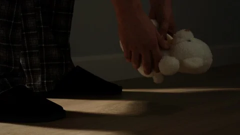 Man Picks Small Plush Bear Toy Up At Home Stock Footage 124623437