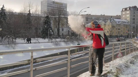 Man Picks Up a Snow From a Ground Throws Snow Down from a Bridge Man Backpacker Stock Footage 59544466