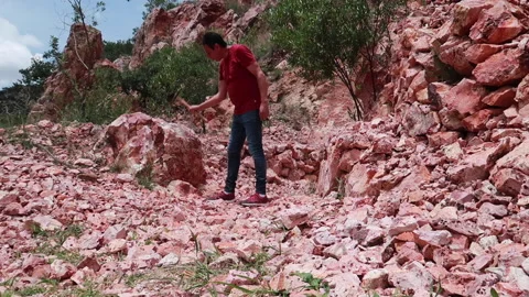 Man picks stone in opal mine with pick tool Stock Footage 158639243