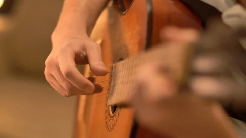 A man picks strings on an old classic guitar, slow motion Stock Footage 120084345