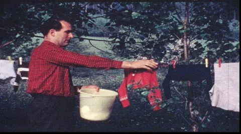 Man picks washing from line (vintage 8 mm amateur film) Stock Footage 825053