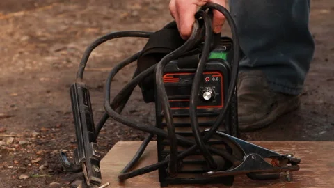 The man picks up the welding machine and goes to work Stock Footage 85984392