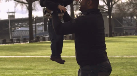 A man picks up a young boy and throws him in the air and catches him 库存影片 33835243
