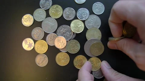 Man pickups coins from black surface Stock Footage 147475730