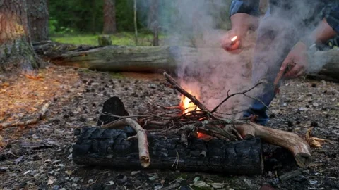 A man on a picnic in the woods lighting a fire Stock-Footage 283670471