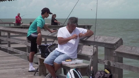 Man on pier preparing to fish Stock Footage 84562952