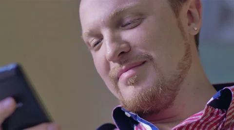 Man with pierced ears using a smartphone Stock Footage 49341129