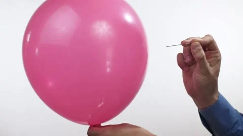 Man pierces a balloon with a needle Stock Footage 133737606