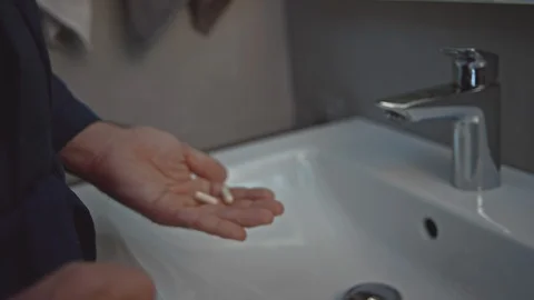 Man with pill bottle in bathroom Video stock 107325070