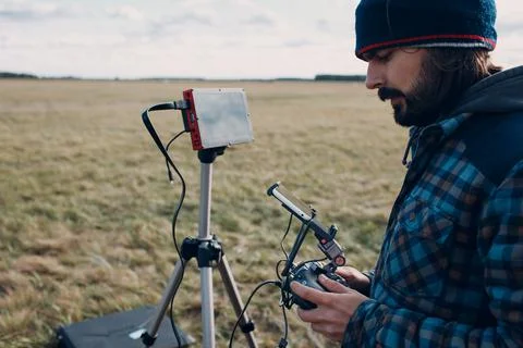Man pilot controlling quadcopter drone with remote controller pad Stock Photos