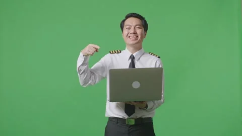 Man Pilot Smiling And Pointing To A Laptop In His Hand Standing ON Green Screen Stock Footage 244394841