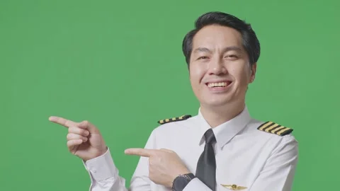Man Pilot Smiling And Pointing To Side While Standing In The Green Screen Stock Footage 244396709
