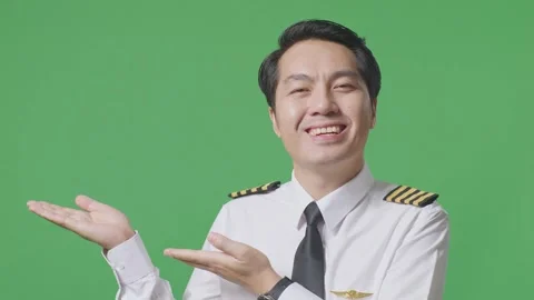 Man Pilot Smiling And Pointing To Side While Standing In The Green Screen Stock Footage 244396750