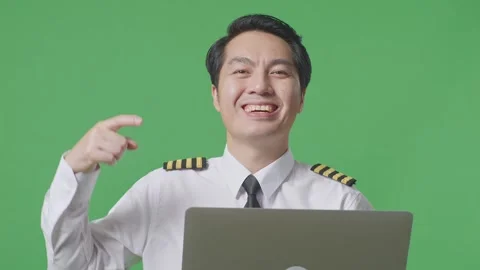 Man Pilot Smiling And Pointing To A Laptop In His Hand Standing ON Green Screen Stock Footage 244398127