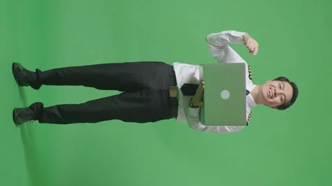 Man Pilot Smiling And Pointing To A Laptop In His Hand Standing ON Green Screen Stock Footage 244400709