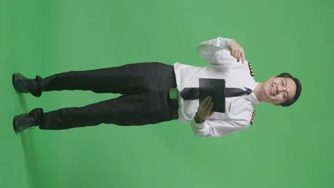 Man Pilot Smiling And Pointing To Tablet In His Hand Standing On Green Screen Stock Footage 244400959