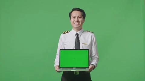 Man Pilot Smiling And Showing Green Screen Laptop To The Camera On Green Screen Stock Footage 244394872