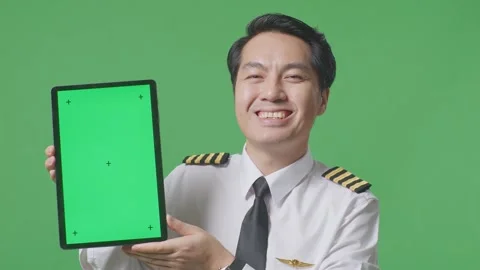Man Pilot Smiling And Showing Green Screen Tablet To The Camera  On Green Screen Stock Footage 244398592