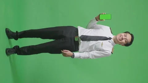 Man Pilot Smiling And Showing Green Screen Smartphone To The Camera Green Screen Stock Footage 244400191