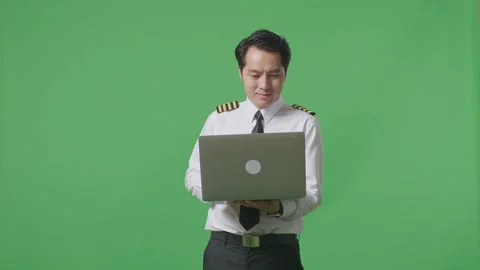 Man Pilot Smiling And Using A Laptop While Standing In The Green Screen Stock Footage 244394661