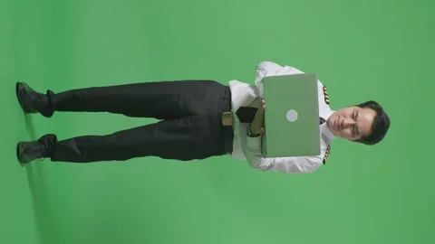 Man Pilot Smiling And Using A Laptop While Standing In The Green Screen Stock Footage 244400548