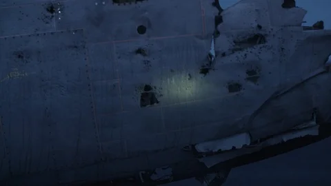 Man in pilot suit walking around a wrecked plane on an Iceland beach Video stock 104239857