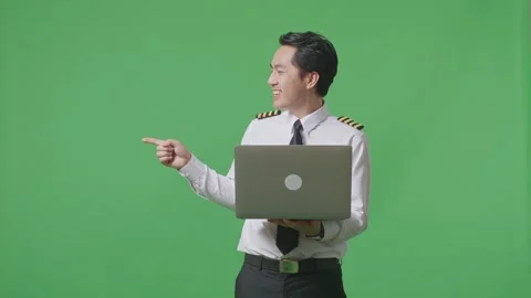 Man Pilot Using A Laptop And Pointing To Side While Standing In The Green Screen Stock Footage 244394815