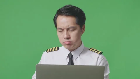 Man Pilot Using A Laptop And Having A Headache While Standing On Green Screen Stock Footage 244397950