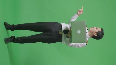 Man Pilot Using A Laptop And Pointing To Side While Standing In The Green Screen Stock Footage 244400665