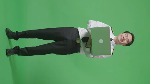 Man Pilot Using A Laptop And Smiling To Camera While Standing On Green Screen Stock Footage 244400743