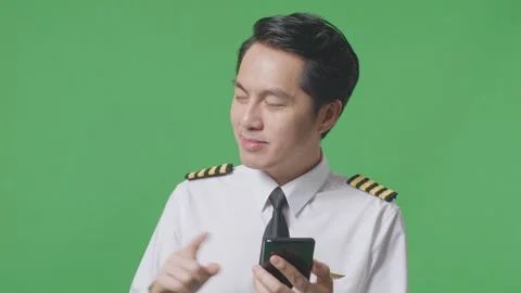 Man Pilot Using Smartphone And Pointing To Side While Standing On Green Screen Stock Footage 244397127