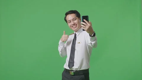 Man Pilot Using Smartphone Taking Picture While Standing In The Green Screen Stock Footage 244394306