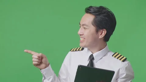 Man Pilot Using A Tablet And Pointing To Side While Standing In The Green Screen Stock Footage 244398361