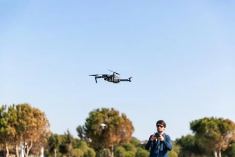 A man piloting a drone in the park in spring-summer time Stock Photos