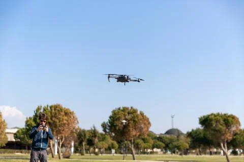 A man piloting a drone in the park in spring-summer time 写真素材