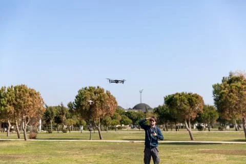 A man piloting a drone in the park in spring-summer time Фото