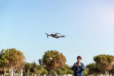 A man piloting a drone in the park in spring-summer time Stock Photos