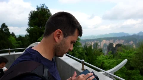 Man piloting a drone with a remote controller at Zhangjiajie park Stock Footage 336694244